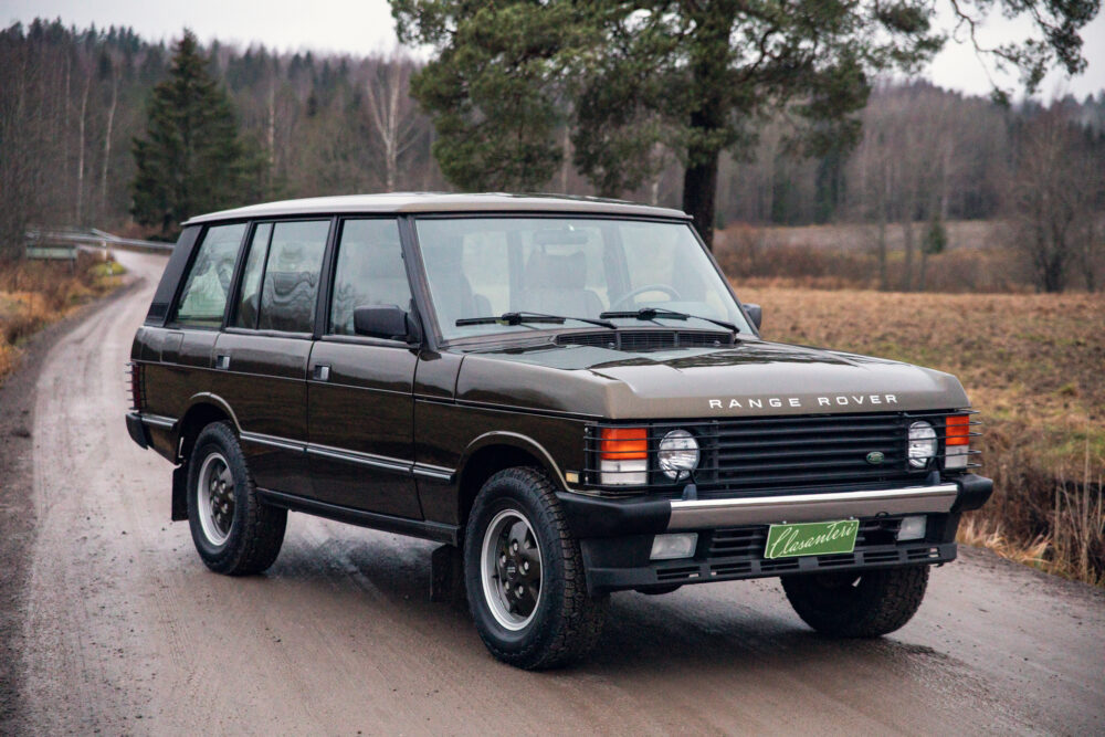 Vintage Range Rover driving on a rural road