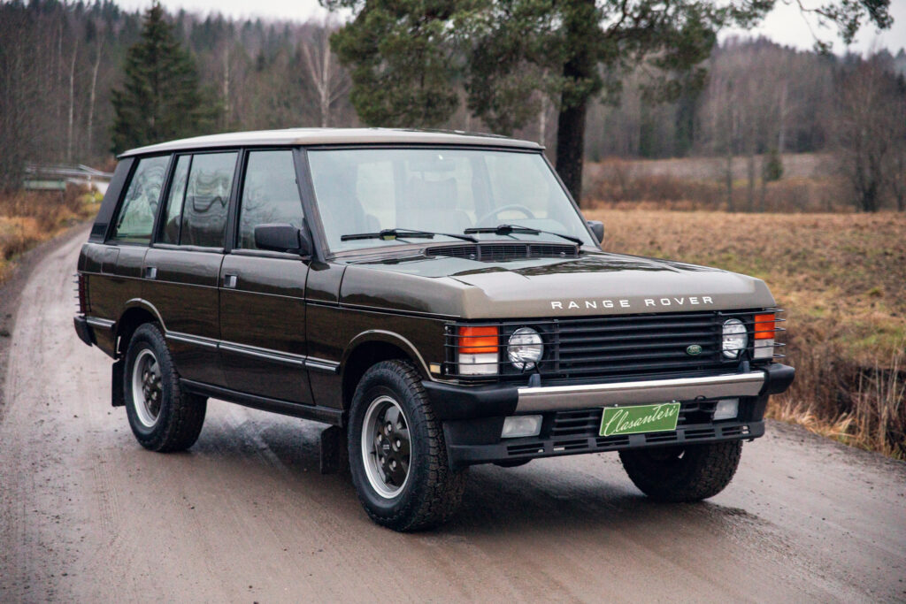 Vintage Range Rover driving on a rural road