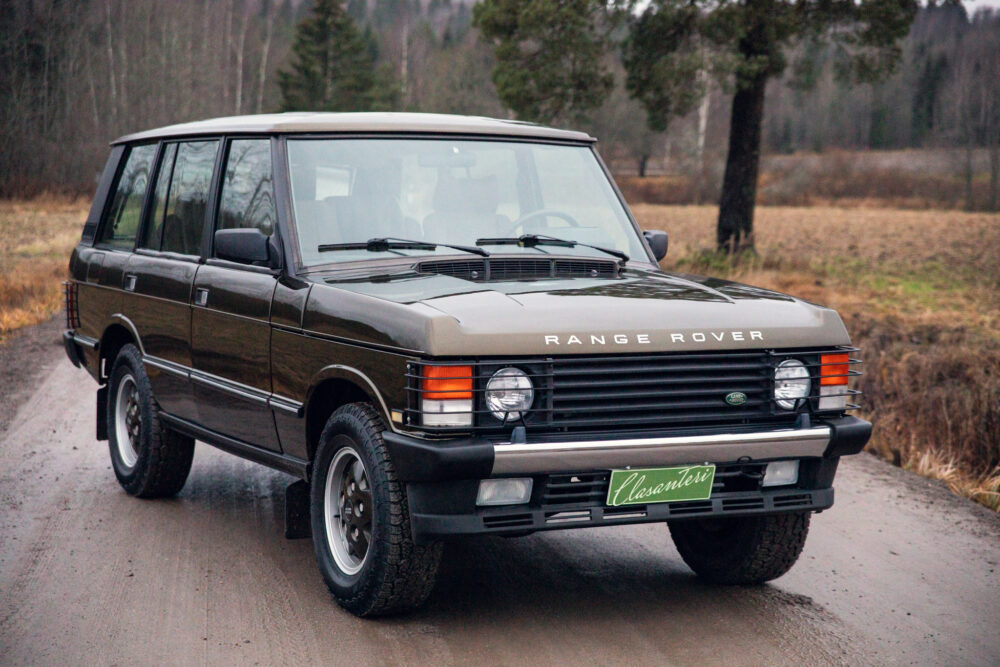 Vintage Range Rover parked on a wet rural road