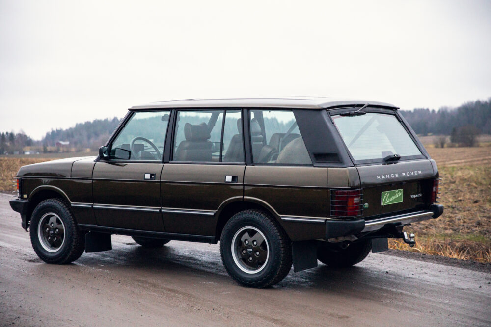 Vintage brown Range Rover parked on country road.