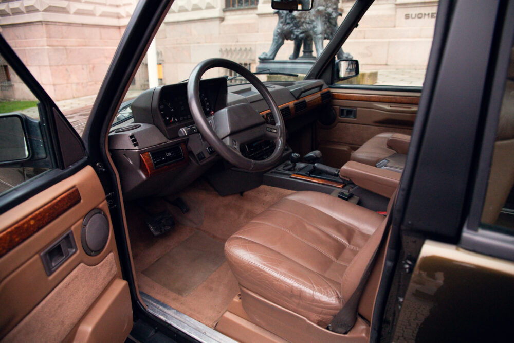 Vintage car interior with leather seats and dashboard.