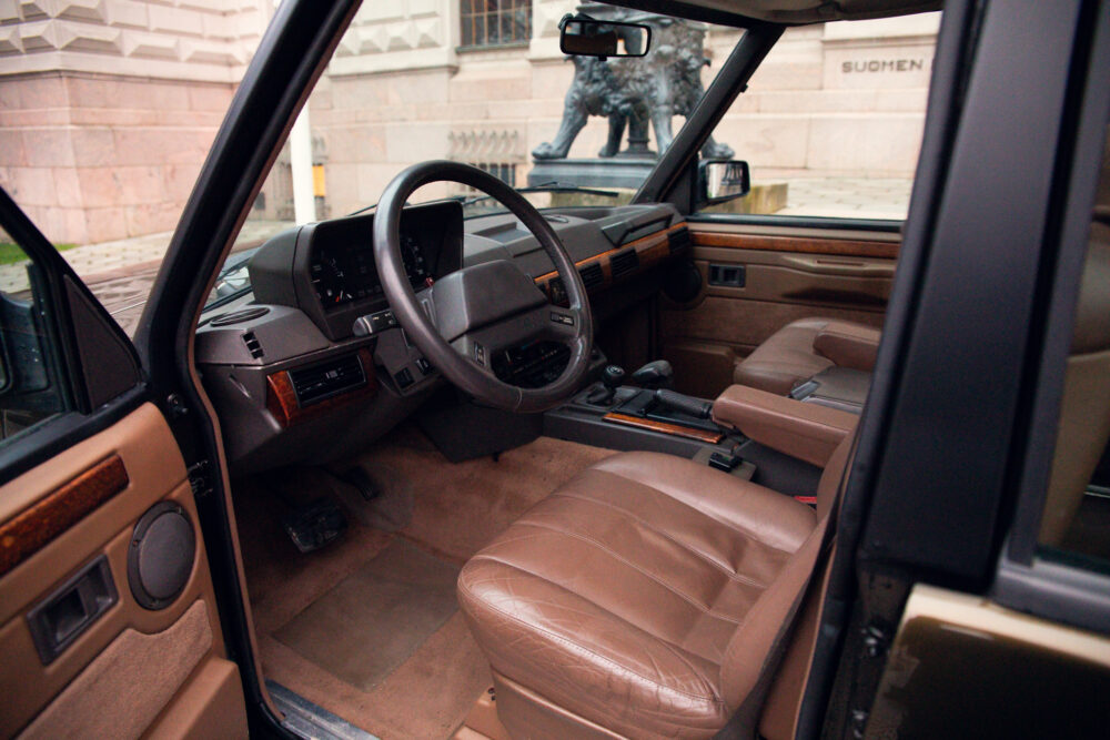Vintage car interior with open door and leather seats