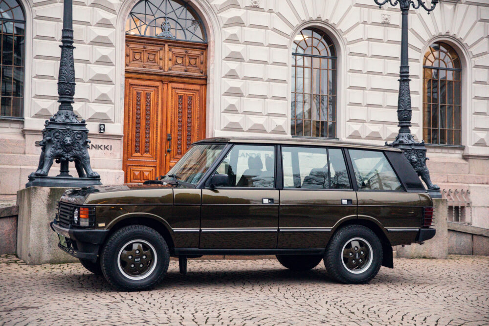 Vintage brown SUV parked near ornate building entrance