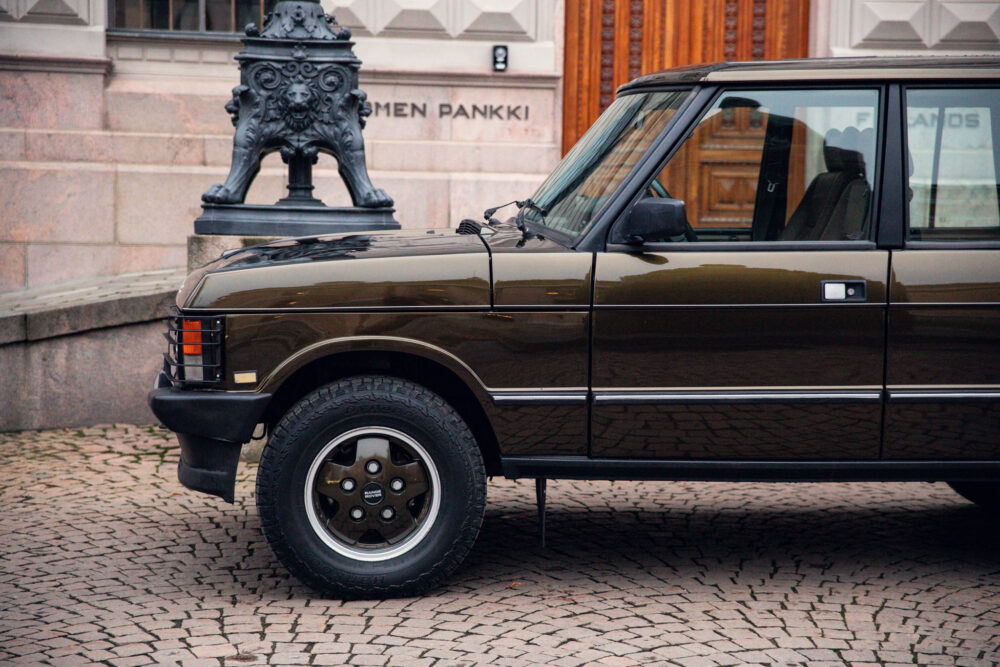 Vintage brown SUV parked near decorative lion statue