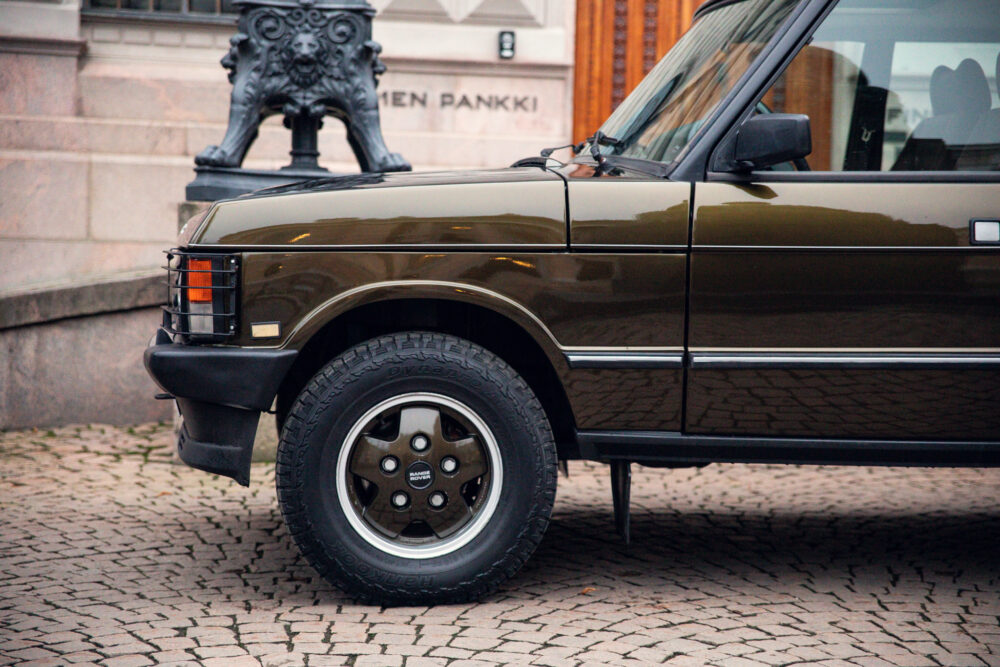 Vintage brown car parked on cobblestone street