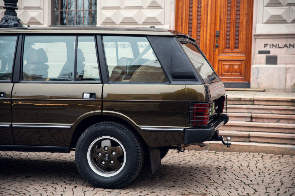 Vintage brown SUV parked near ornate building entrance