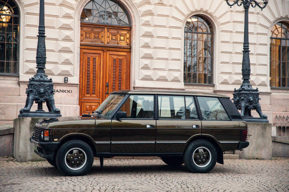Vintage SUV parked near decorative building entrance