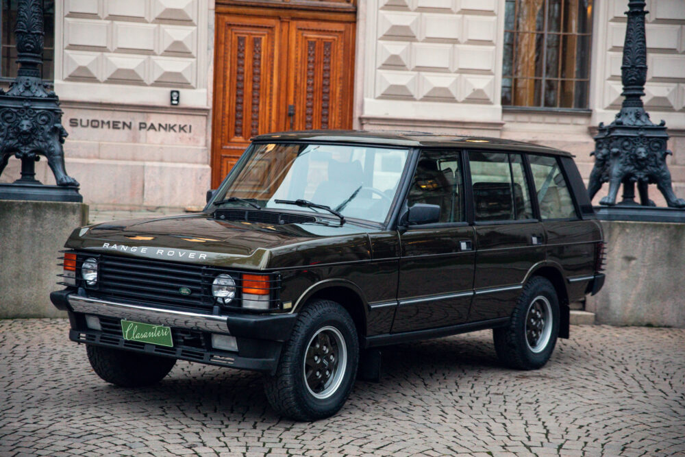 Vintage Range Rover parked outside historic building