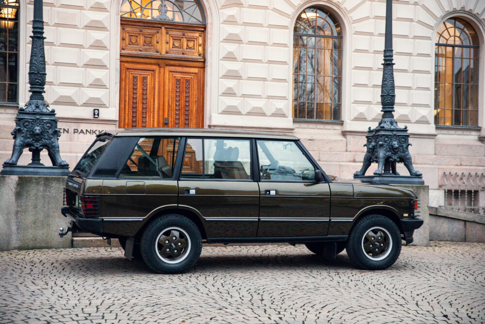 Vintage green SUV parked near ornate building entrance