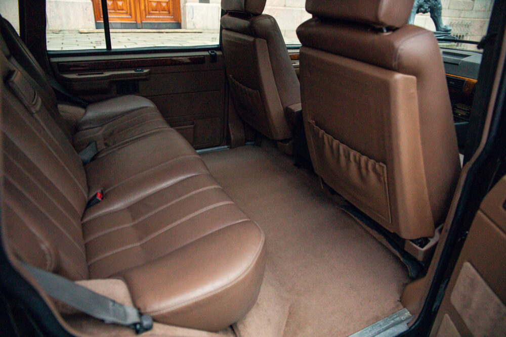 Spacious brown leather car interior with open door