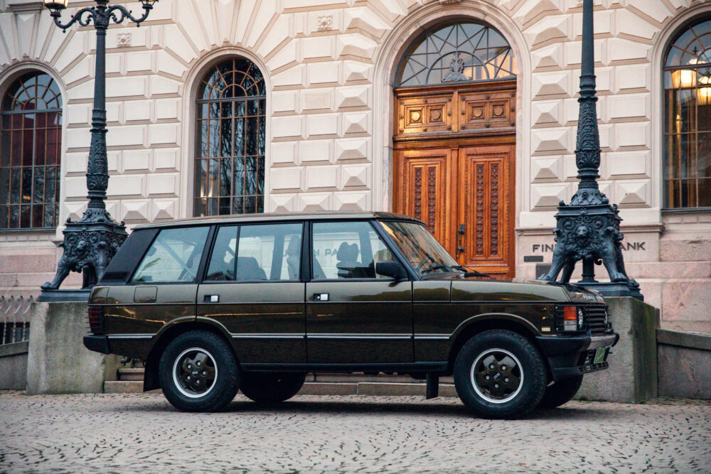 Vintage green SUV parked near ornate historic building