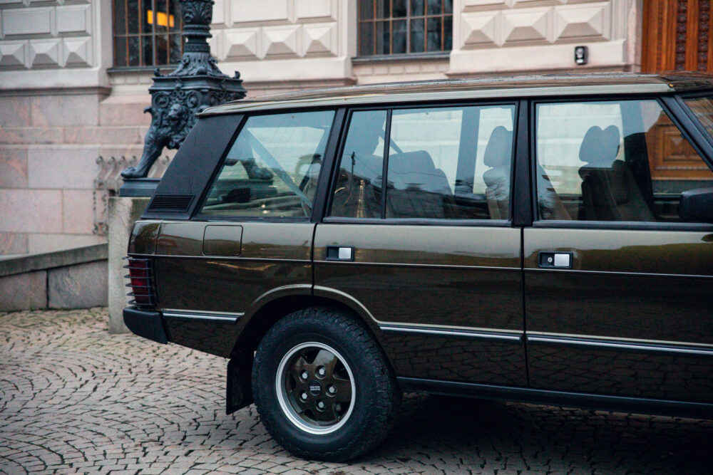 Vintage brown car parked by cobblestone street