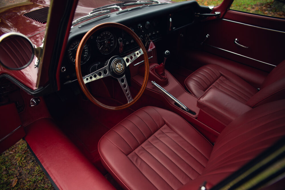 Vintage red car interior, leather seats and wooden dashboard