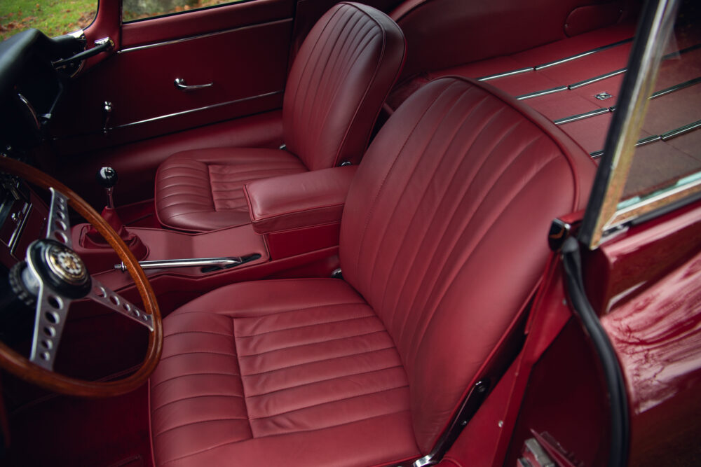 Vintage red car interior with polished wood dashboard
