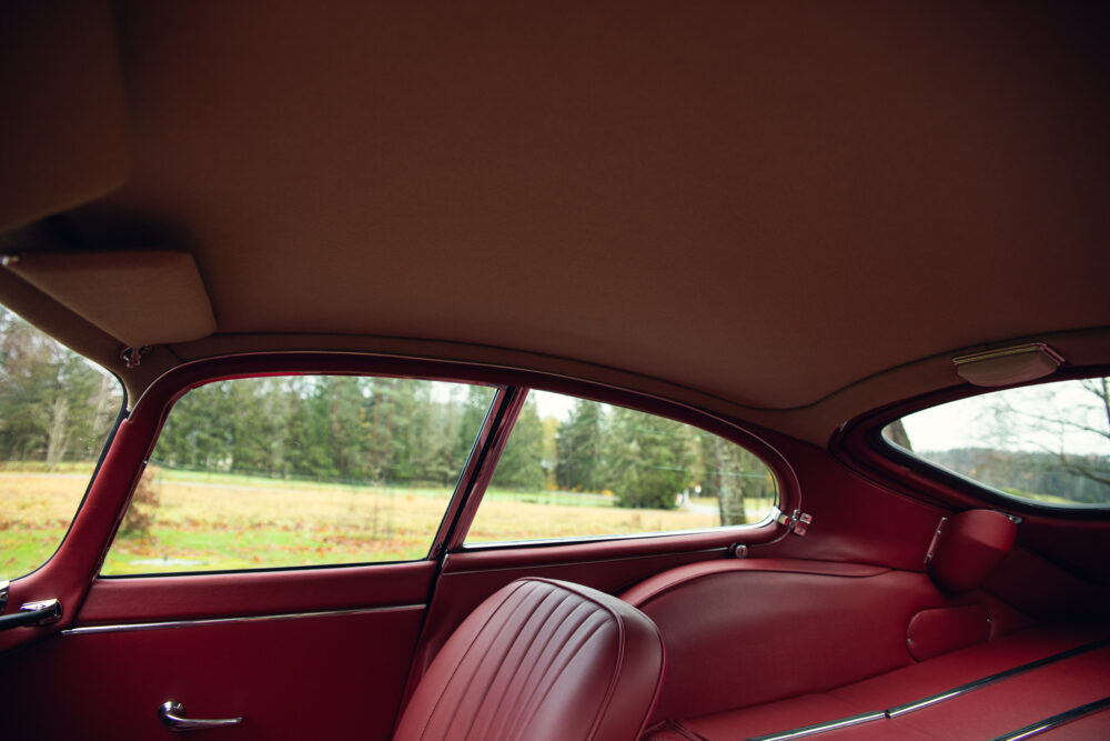 Vintage car interior with lush red seats and window view