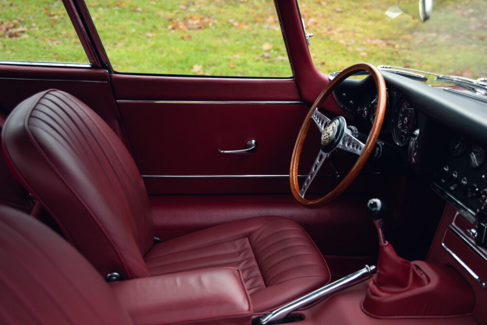 Vintage car interior with red leather seats and wooden steering wheel