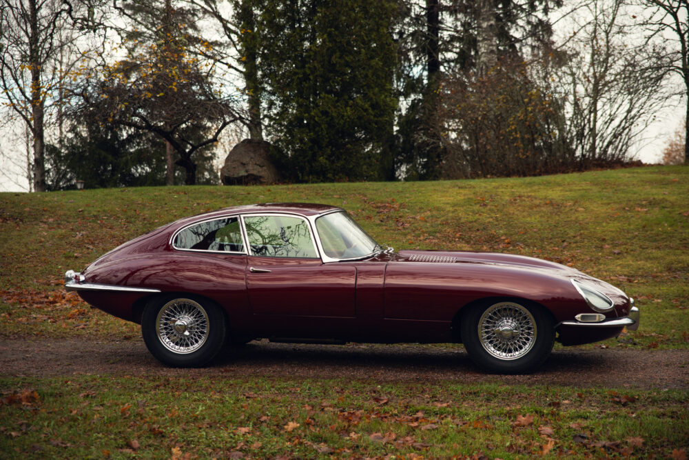 Vintage red Jaguar E-Type on grassy field