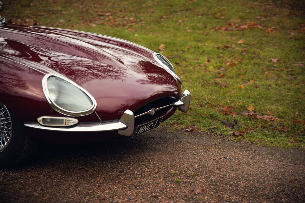 Vintage red car front close-up on autumn road