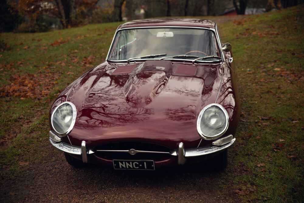 Vintage maroon Jaguar E-Type car on autumn day