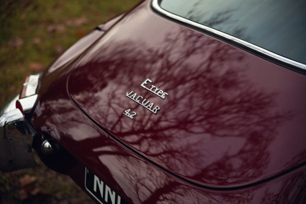 Close-up of red Jaguar E-Type car logo