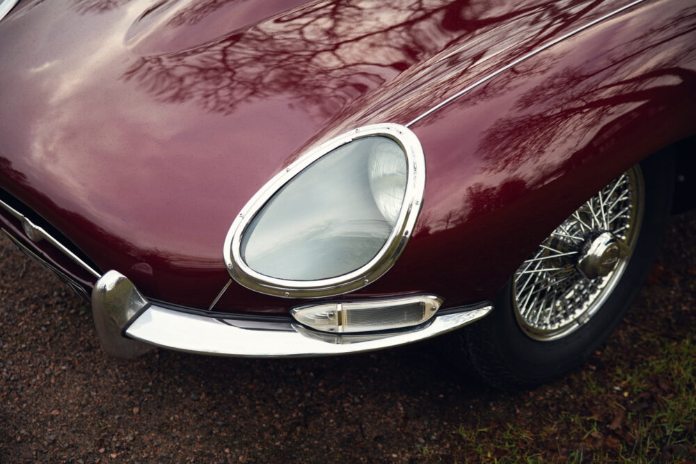 Vintage red car with chrome headlight and wire wheel
