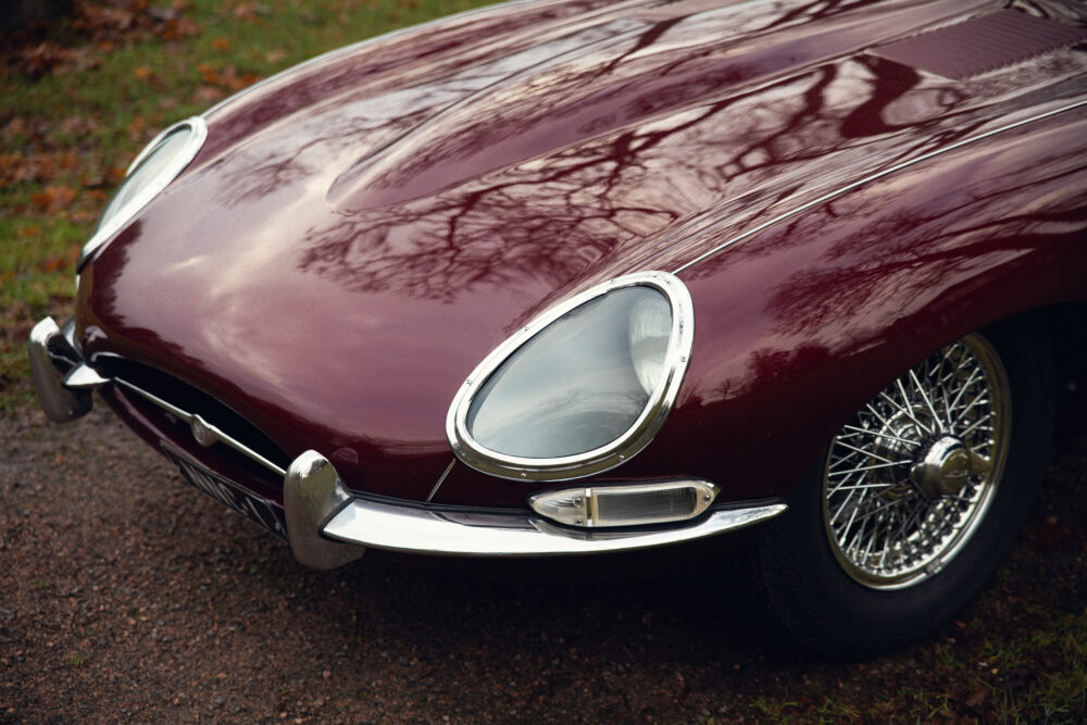 Vintage burgundy car with chrome accents and wire wheels