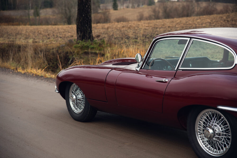 Classic red car with chrome wheels on country road
