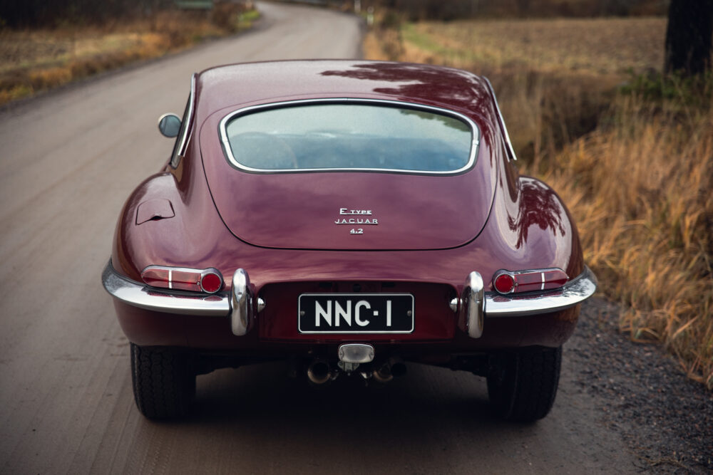 Vintage maroon Jaguar E-Type car on a country road