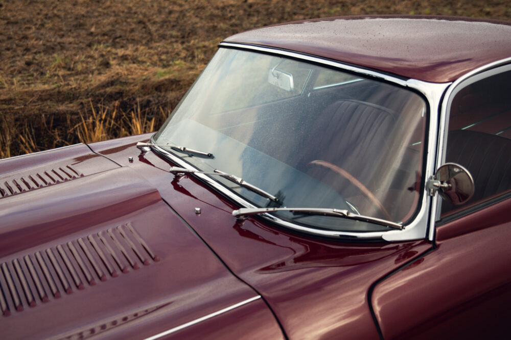 Vintage burgundy car with chrome windshield wipers