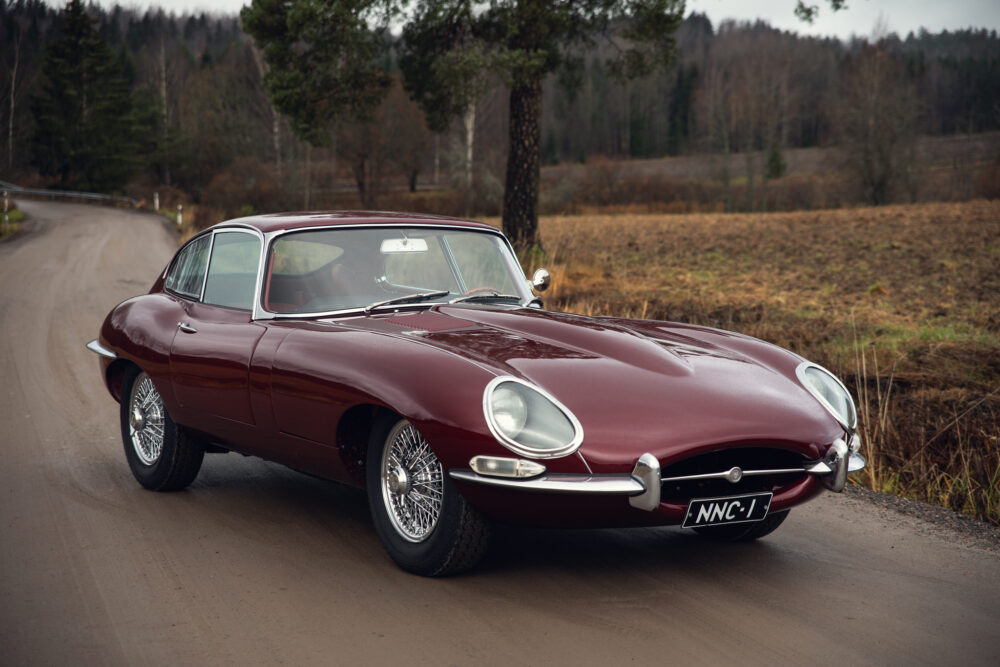 Vintage red Jaguar E-Type on a forest road