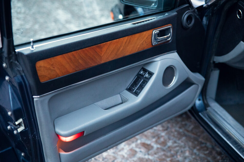 Luxury car door interior with wooden panel and controls