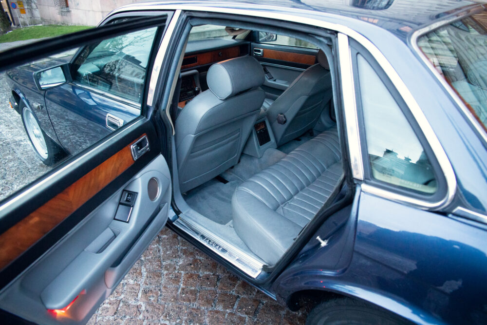 Luxurious car interior with open door and leather seats.