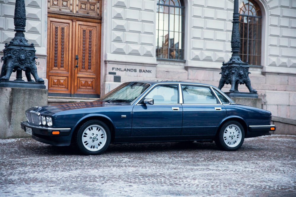 Vintage blue car parked outside Finland's Bank building