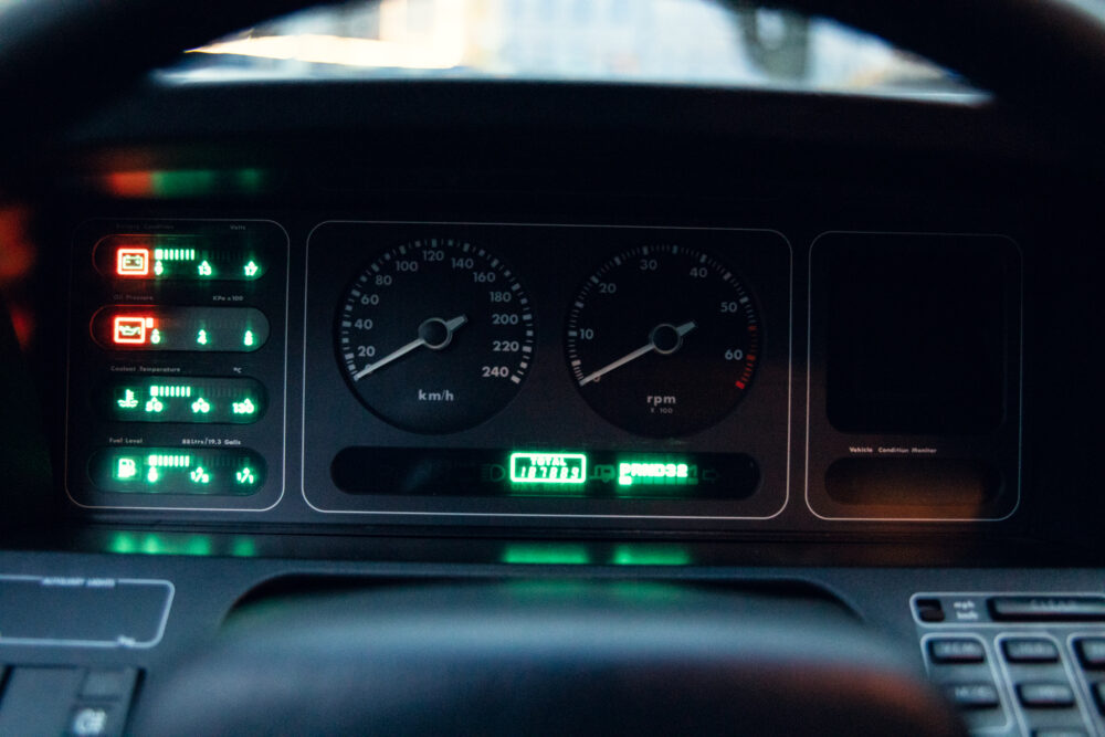 Car dashboard with illuminated gauges and indicators at night