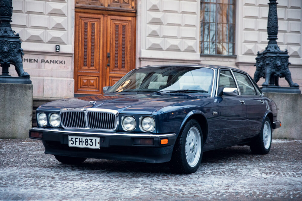 Vintage blue Jaguar car parked outside elegant building