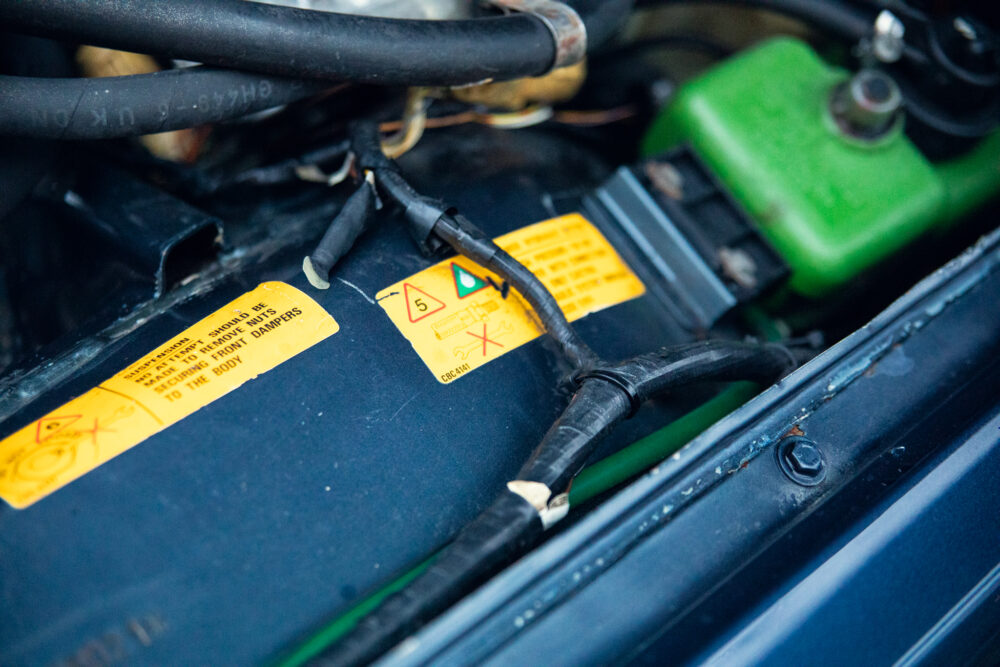 Close-up of car battery with warning labels
