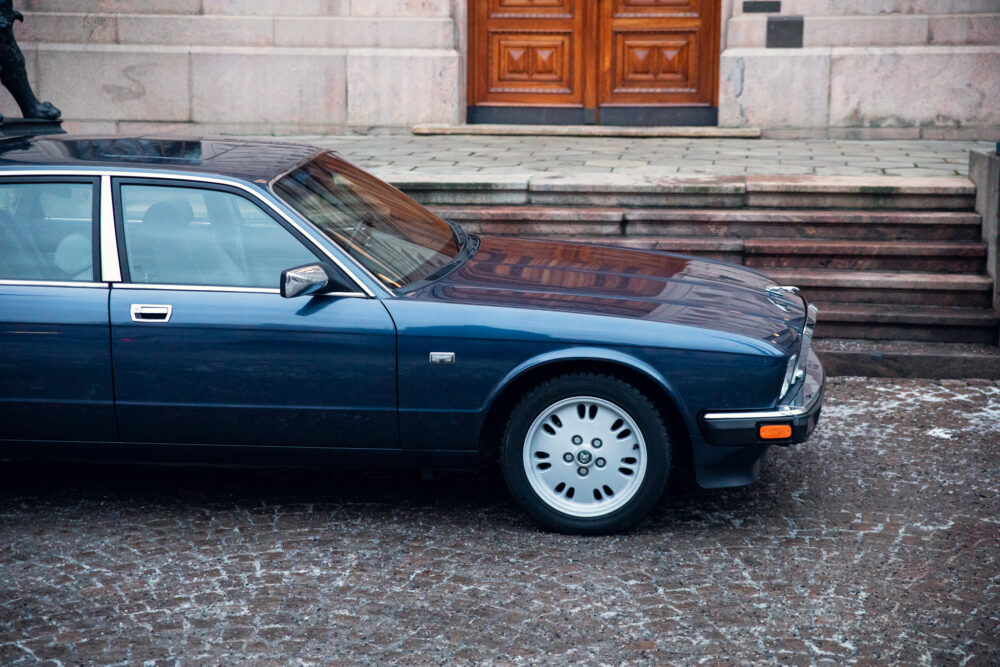 Blue vintage car parked near stone steps