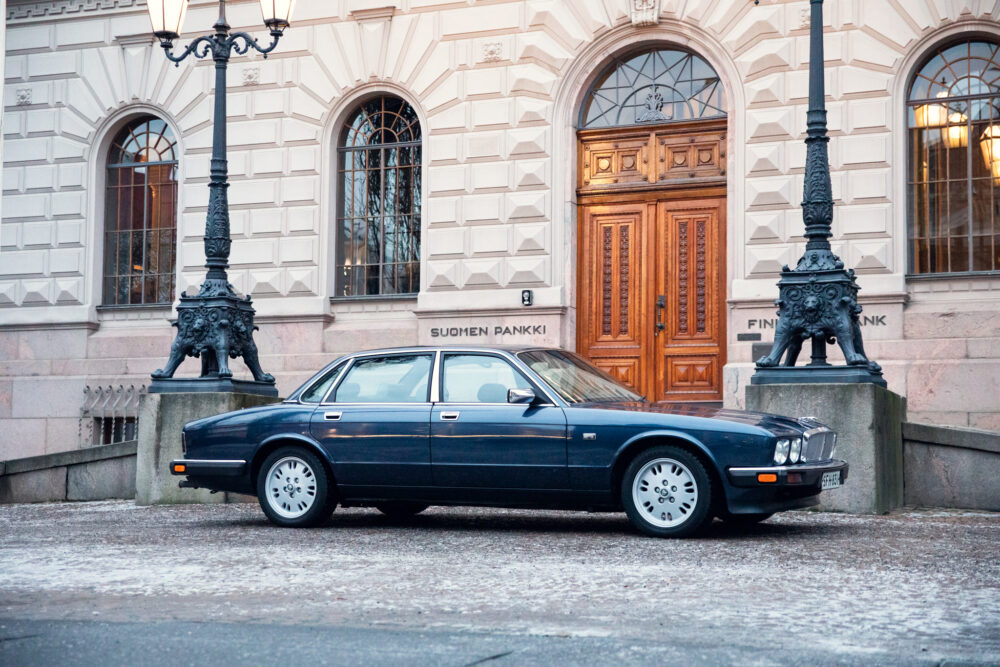 Blue sedan parked outside Suomen Pankki building