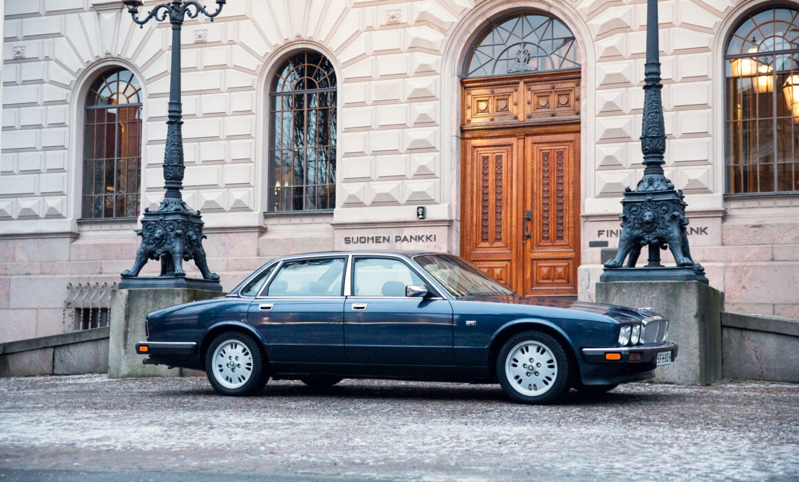 Blue sedan parked outside Suomen Pankki building