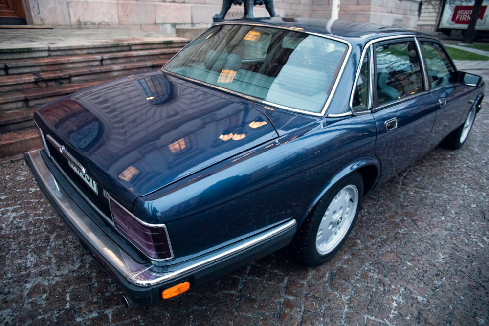 Vintage blue Volvo sedan parked near stone stairs