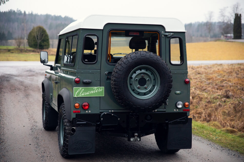 Green Land Rover Defender parked on rural road