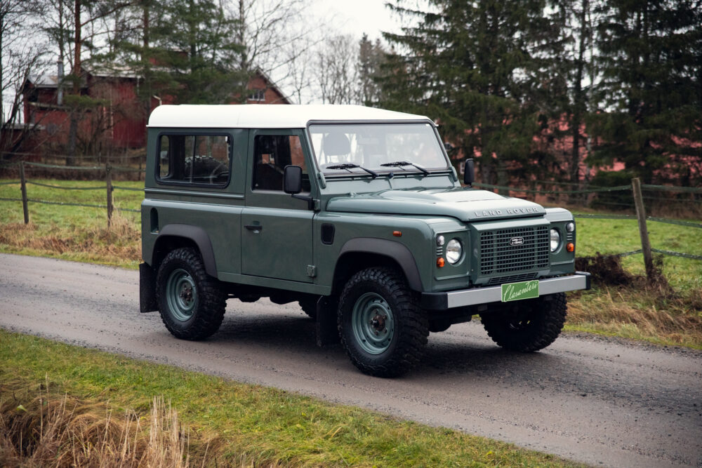 Green Land Rover Defender on rural road