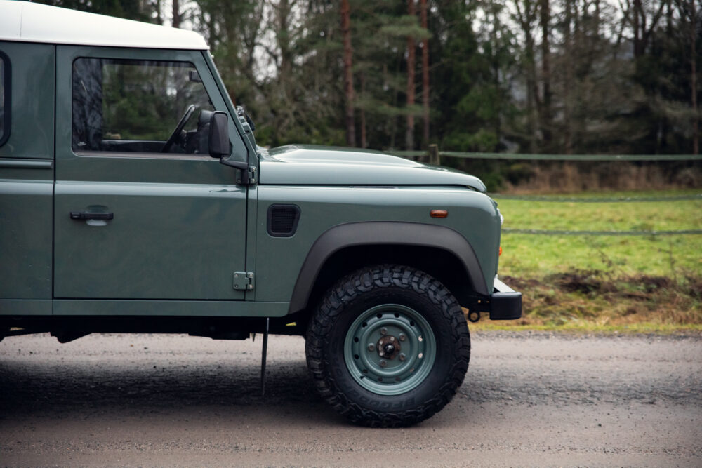 Green off-road vehicle parked on rural road