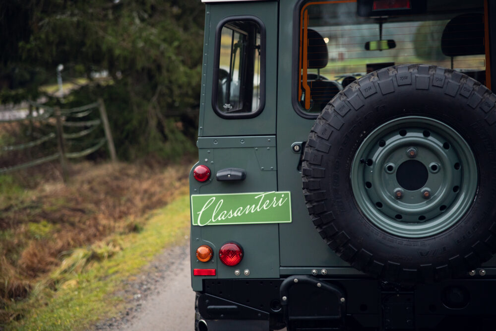 Green off-road vehicle with sign 'Elasanteiri' and spare tire