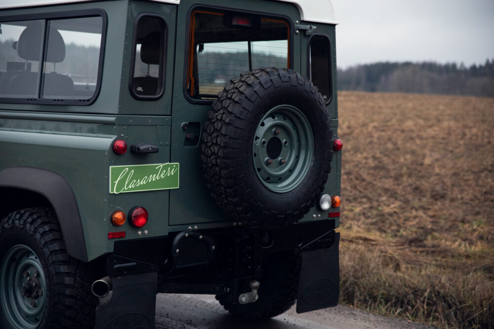 Green SUV with spare tire on rural road
