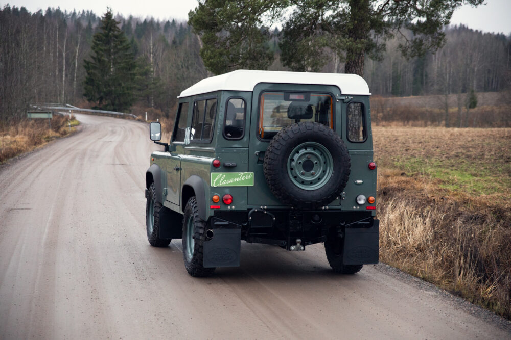 Green classic SUV on rural road