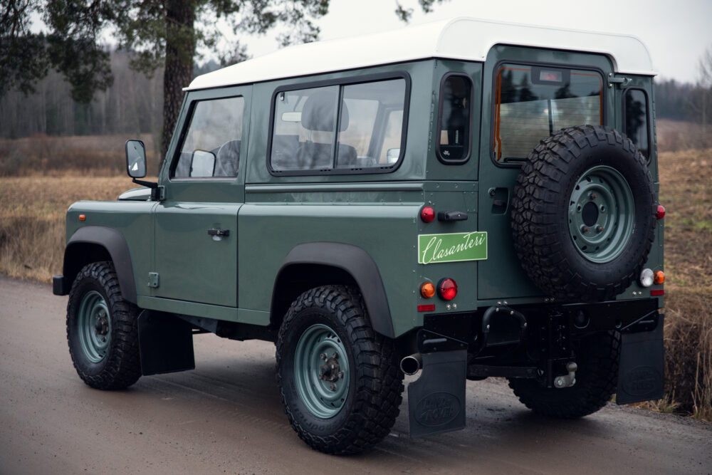 Vintage green Land Rover on forest road