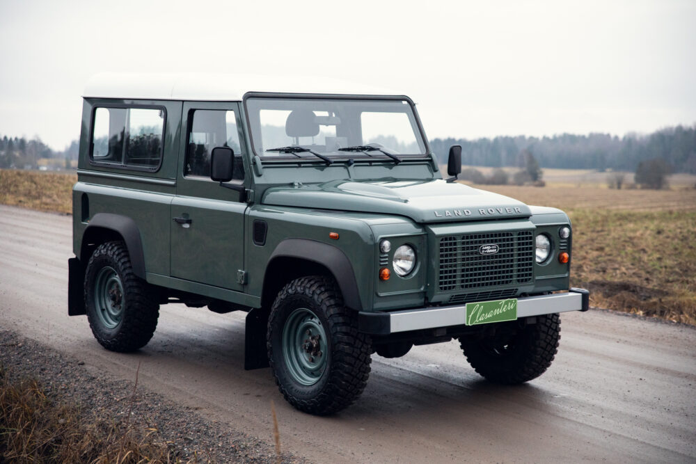 Green Land Rover Defender on rural road