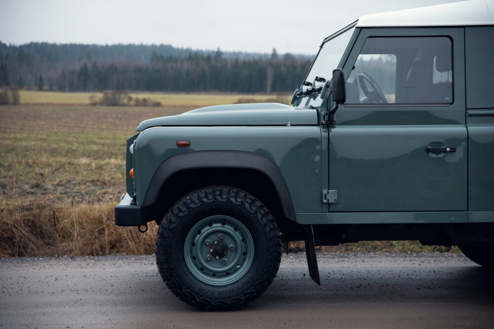 Green off-road vehicle on rural road near fields