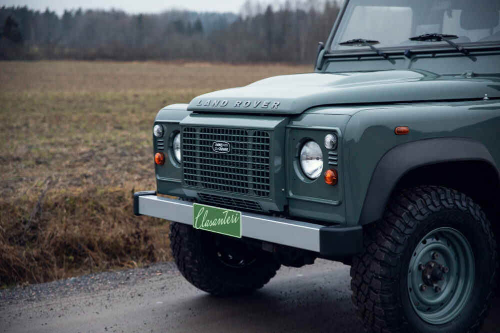 Green Land Rover Defender in a field